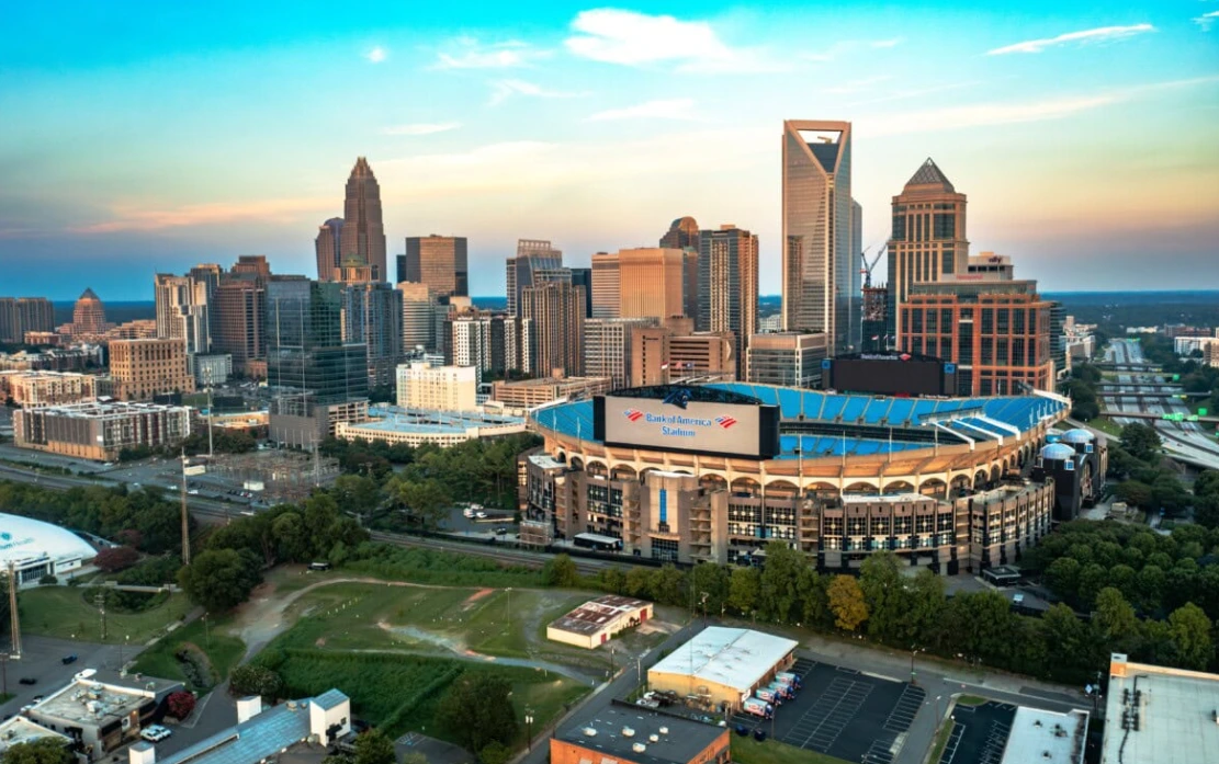 A team of Google Ads professionals reviewing data on a monitor in an office with a view of the Charlotte.